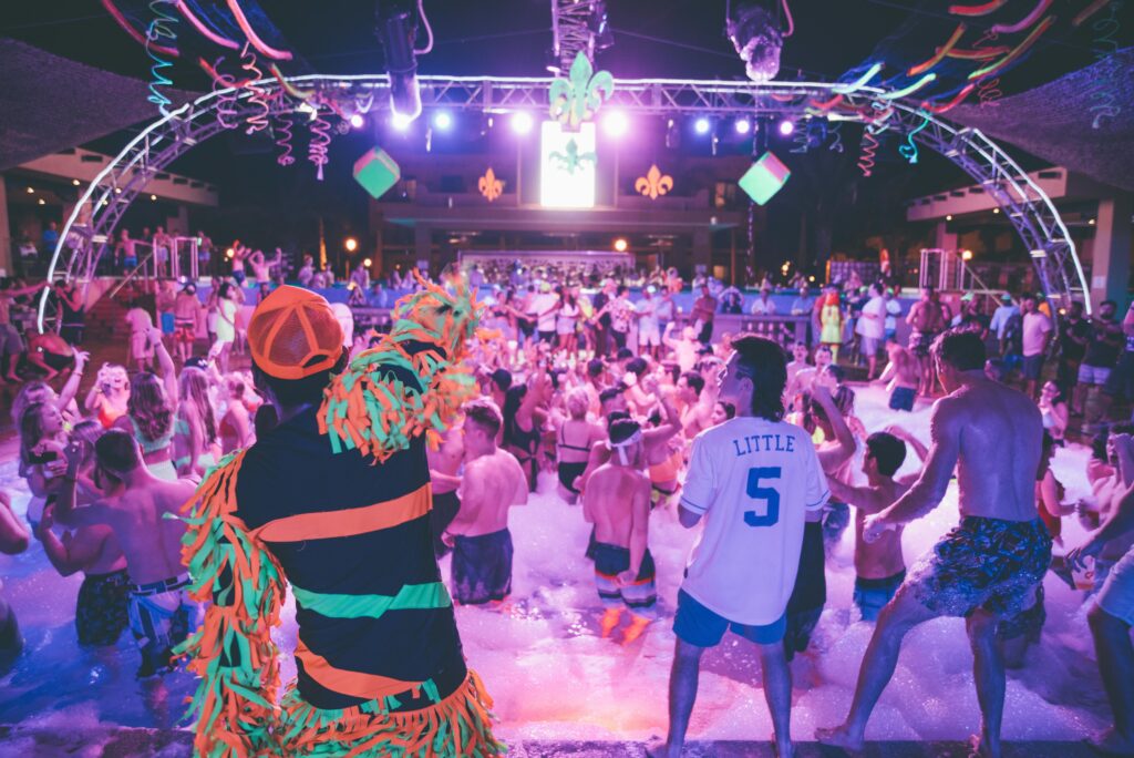 Energetic foam party at night with a lively DJ and young crowd enjoying the vibrant atmosphere.